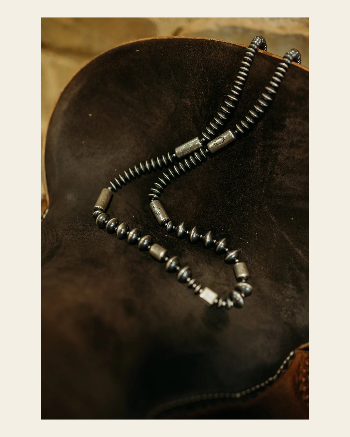 36" Graduated Saucer Pearl With Stamped Barrel Bead Necklace on a warm cream background