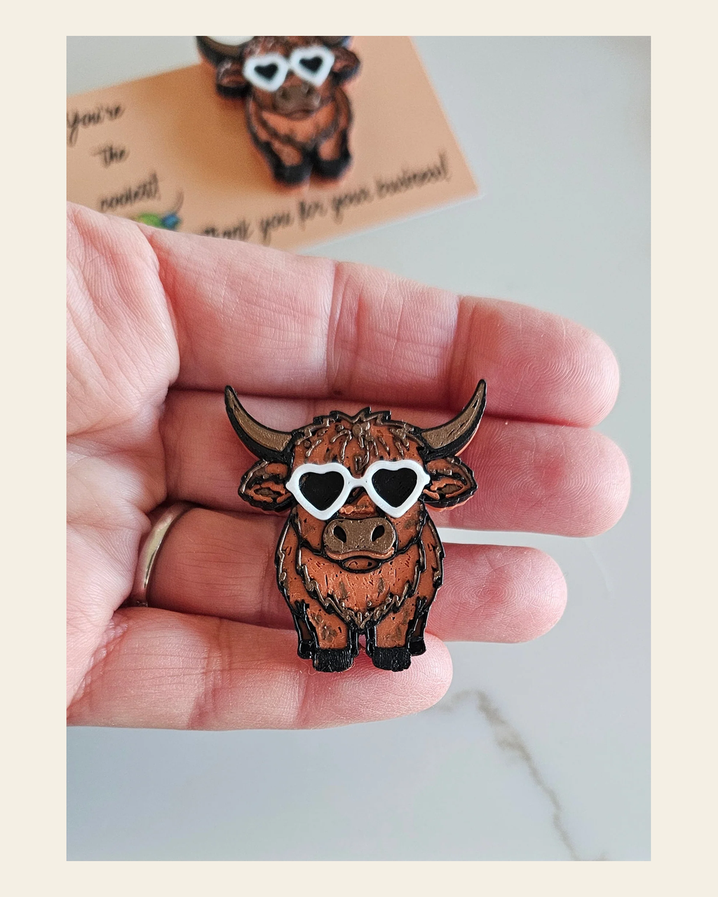 3d  Cool Highland Brown Cow Hat Pin Made in America on a warm cream background