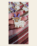 3d Easter Highland Cow Bunny Hat Pin on a warm cream background
