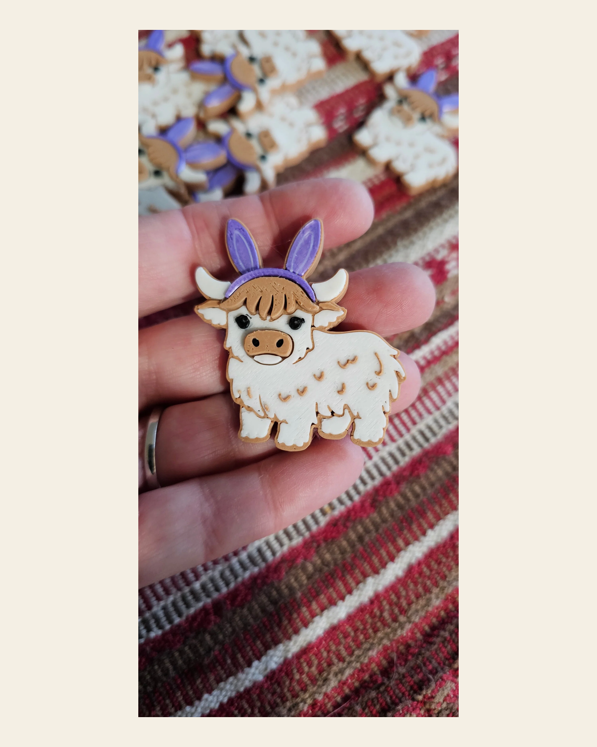 3d Easter Highland Cow Bunny Hat Pin on a warm cream background