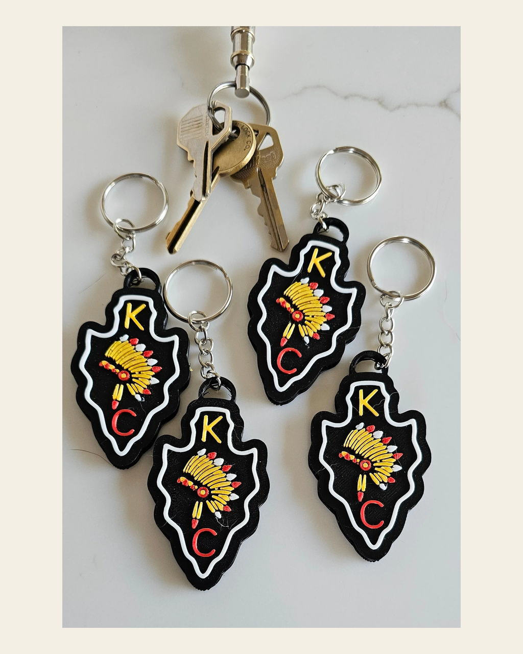 3D Print Chiefs Arrowhead Kc 15 Mahomes Kansas City 87 Kelce Football Keychain Made in America on a warm cream background
