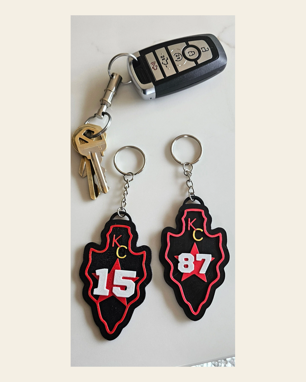 3D Print Chiefs Arrowhead Kc 15 Mahomes Kansas City 87 Kelce Football Keychain Made in America on a warm cream background