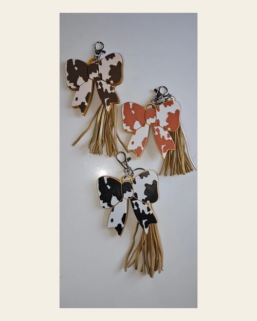 3d Print Puffy Bow Trend Keychain Fringe Cow Print Western Made in America on a warm cream background