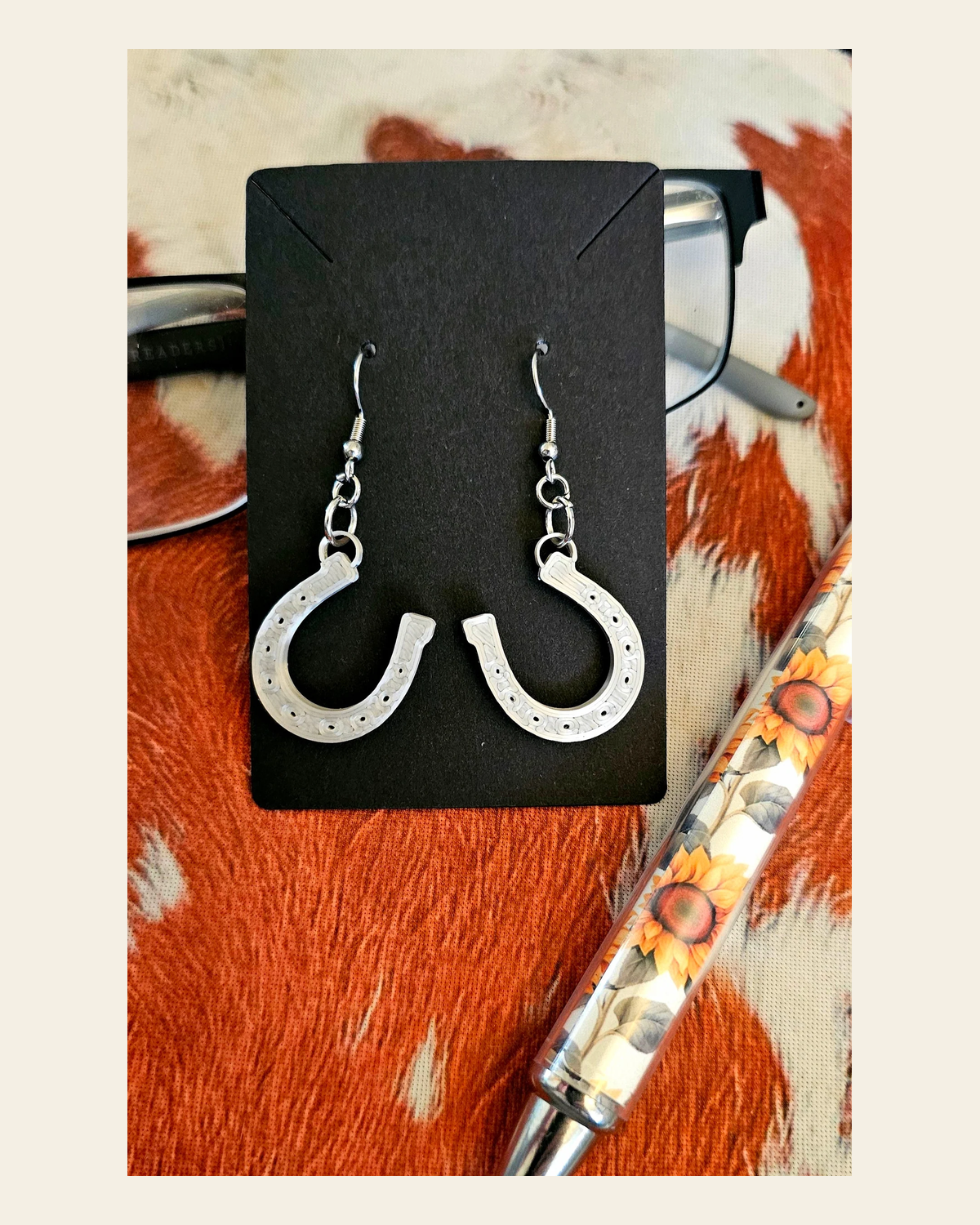 3D Print Western Silver Horseshoe Earrings Made in America on a warm cream background