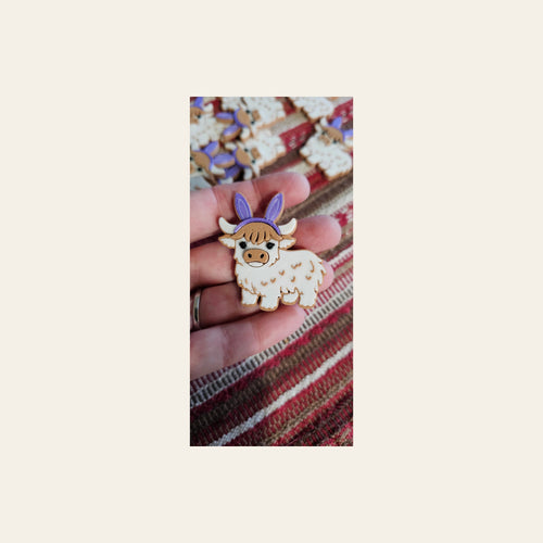 3d Easter Highland Cow Bunny Hat Pin on a warm cream background