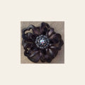 Black Lotus Flower With Antique Silver Jet and AB 1" Concho on a warm cream background