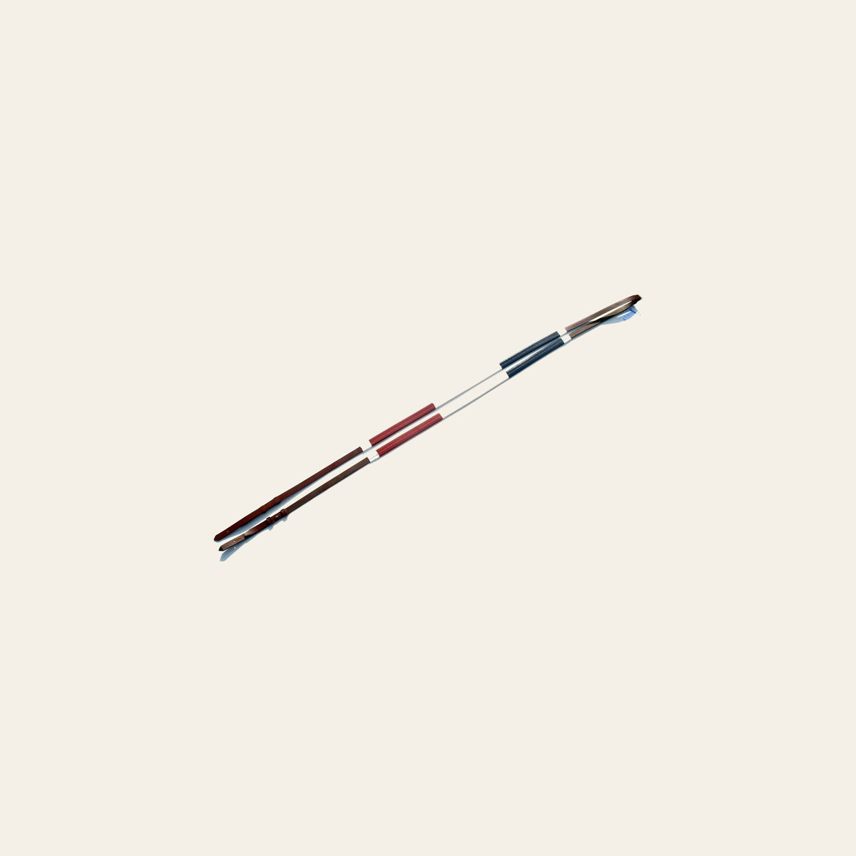 ExionPro Tri-Colour Training Rubber Reins on a warm cream background