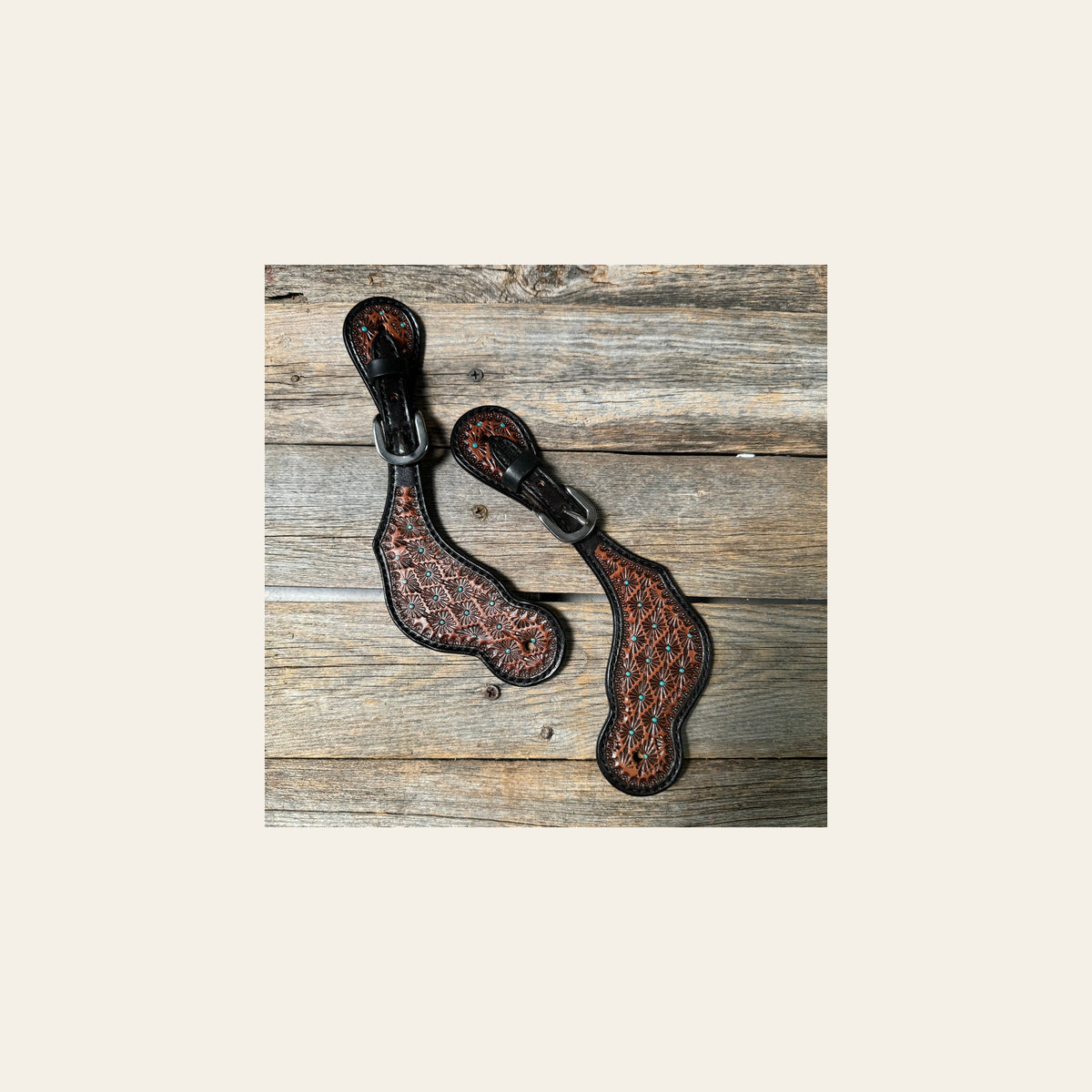 Teal Dot Diamond Tooled Spur Straps on a warm cream background
