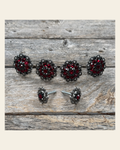 Antique Silver Ruby and Jet Saddle Conchos on a warm cream background