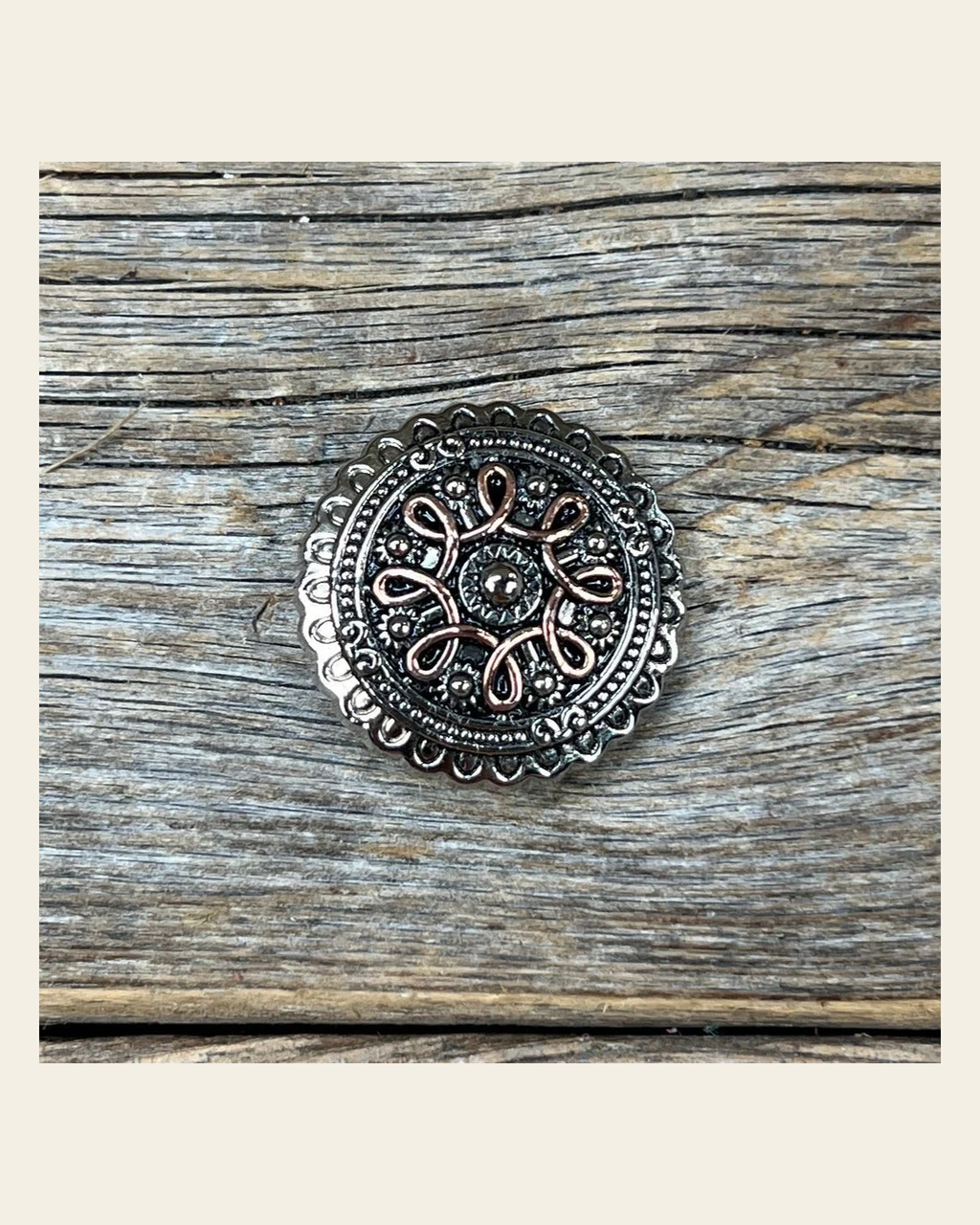 Antique Silver Flower and Loops Concho 1" W235S on a warm cream background