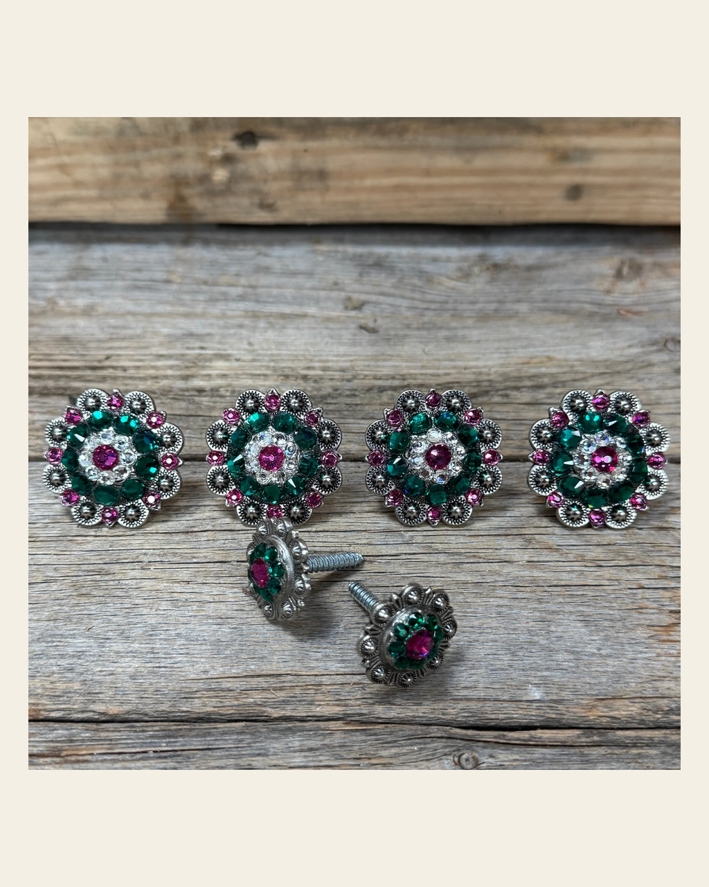 Antique Silver Fuchsia, Clear and Emerald Saddle Conchos on a warm cream background