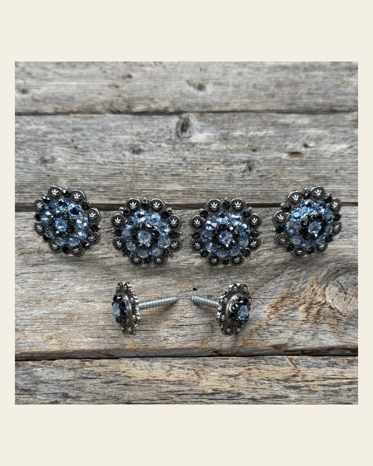 Antique Silver Light Sapphire and Jet Saddle Conchos on a warm cream background