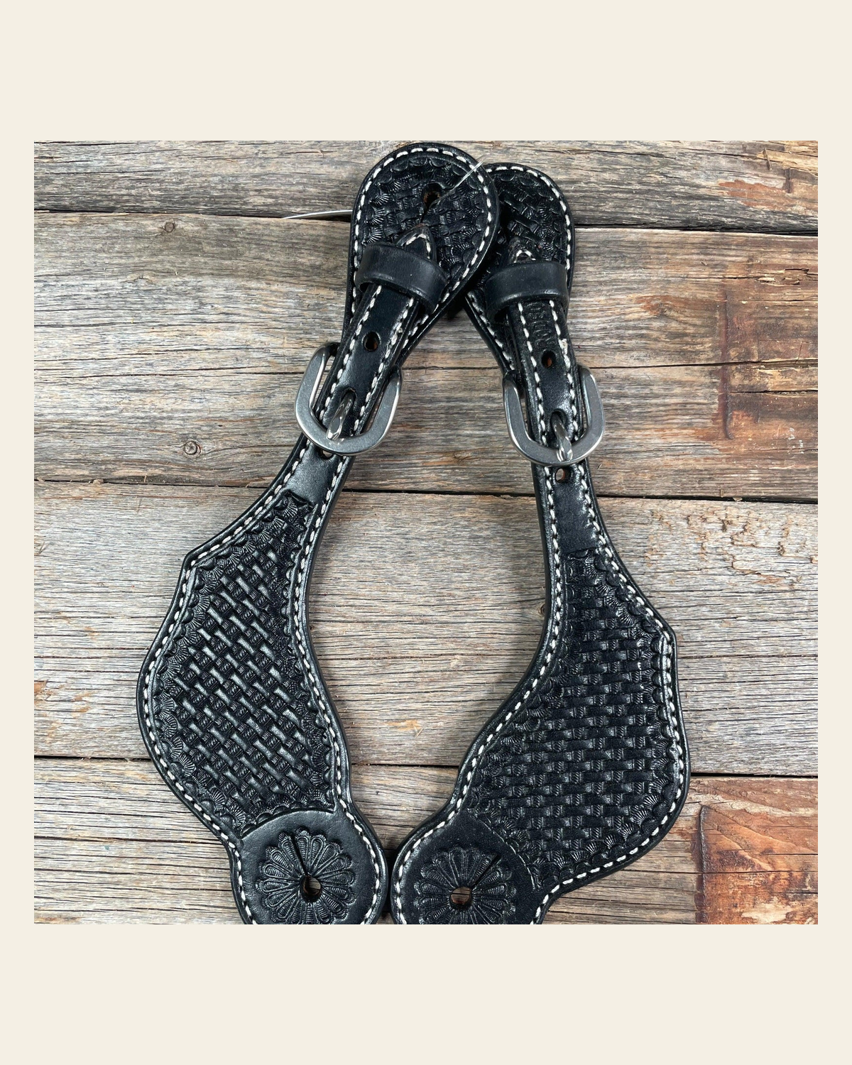 Black Genuine Leather Basketweave Tooled Spur Straps on a warm cream background