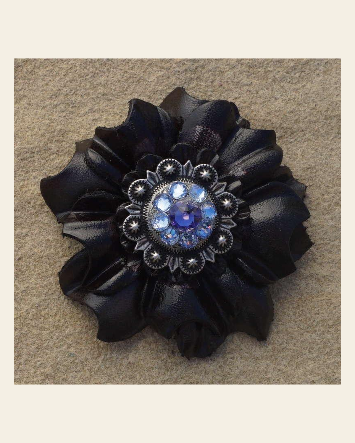Black Carnation Flower With Antique Silver Lilac and Light Sapphire 1" Concho on a warm cream background