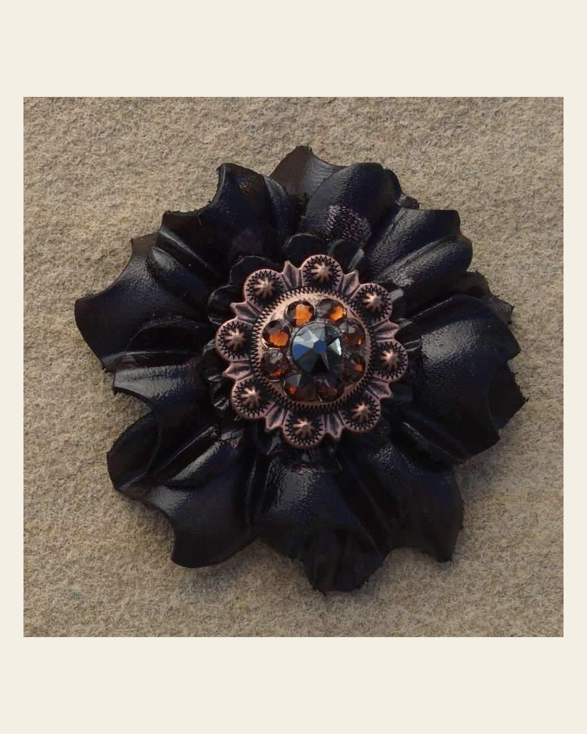Black Carnation Flower With Copper Jet & Topaz 1" Concho on a warm cream background