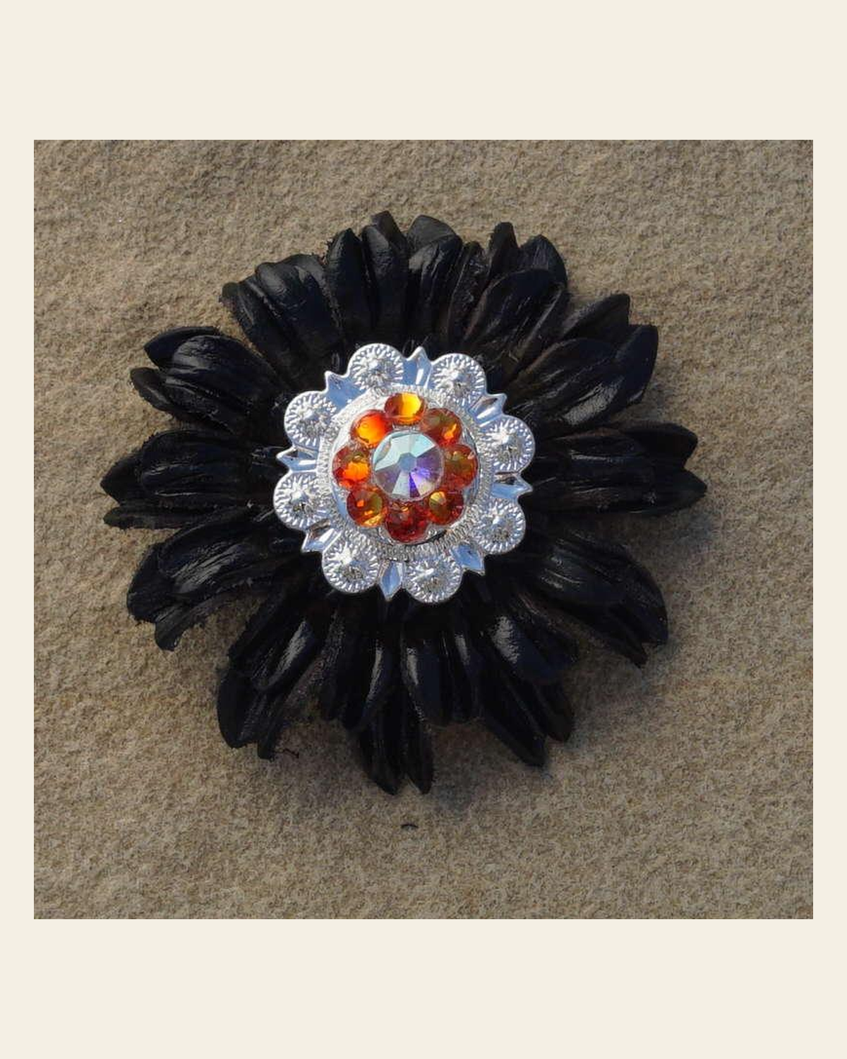 Black Daisy Flower With Bright Silver Fire Opal and AB 1" Concho on a warm cream background