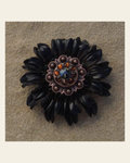 Black Daisy Flower With Copper Jet & Topaz 1" Concho on a warm cream background