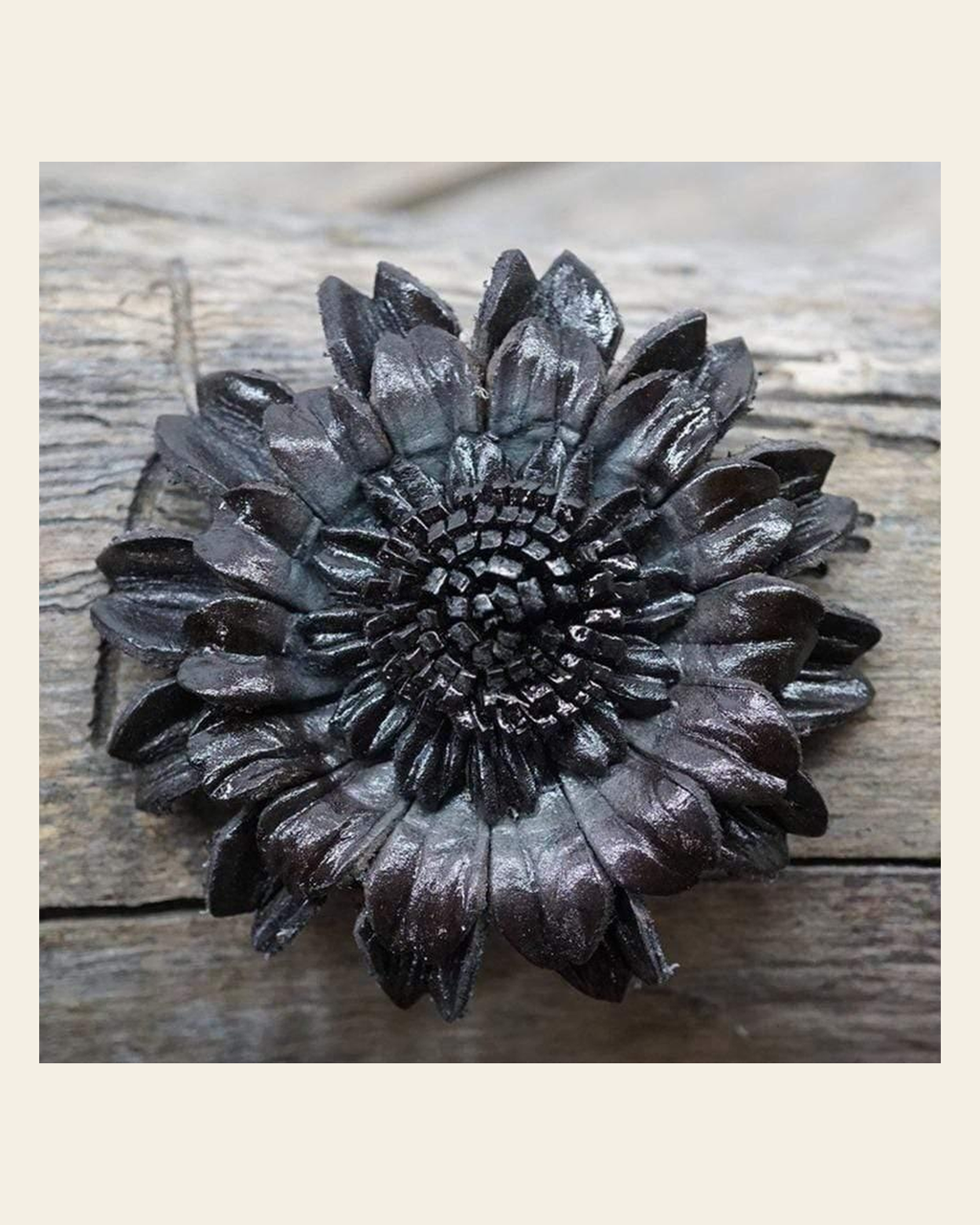 Black Daisy Leather Flower on a warm cream background
