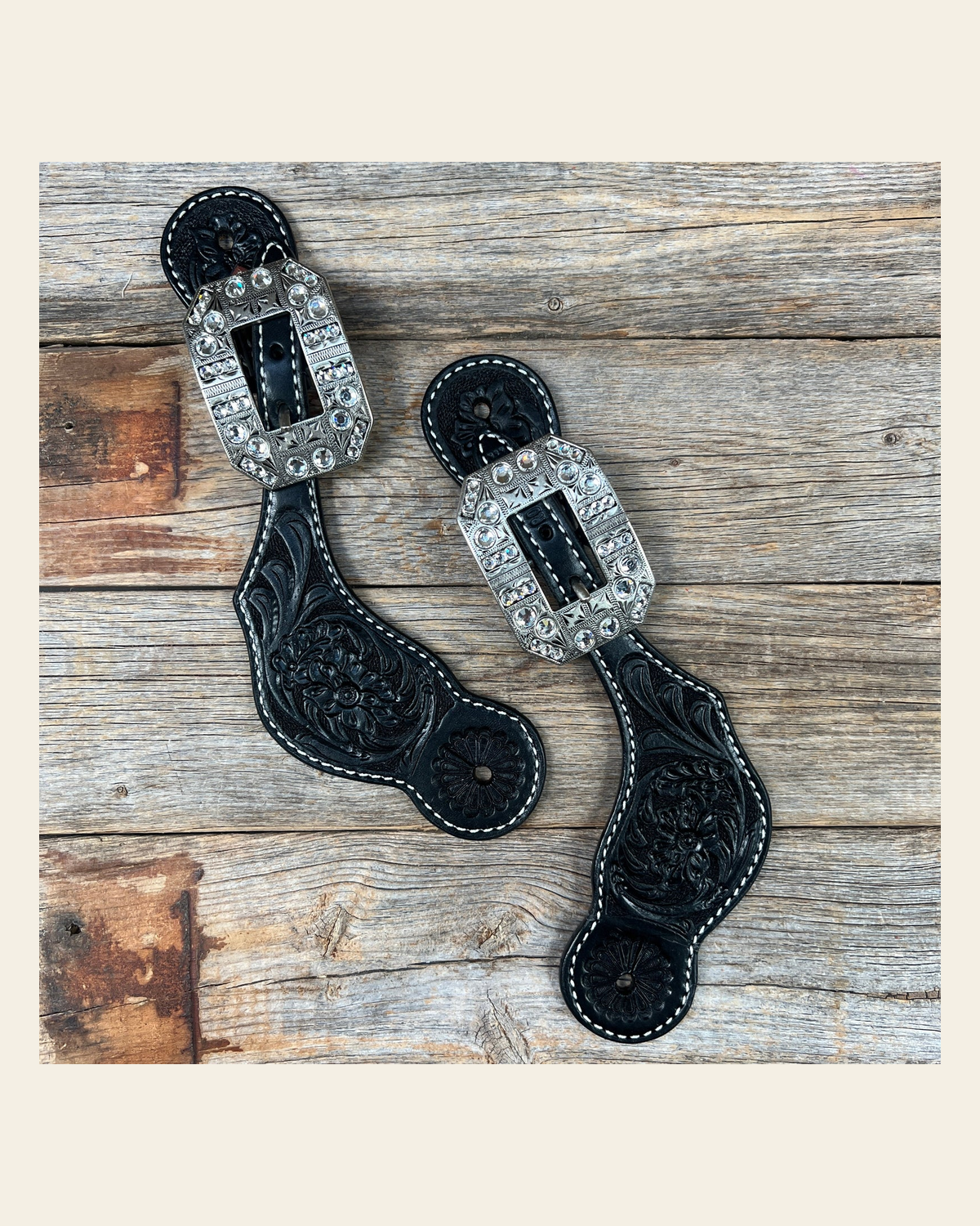 Black Floral Tooled Spur Straps - European Clear Buckles #SS107 on a warm cream background