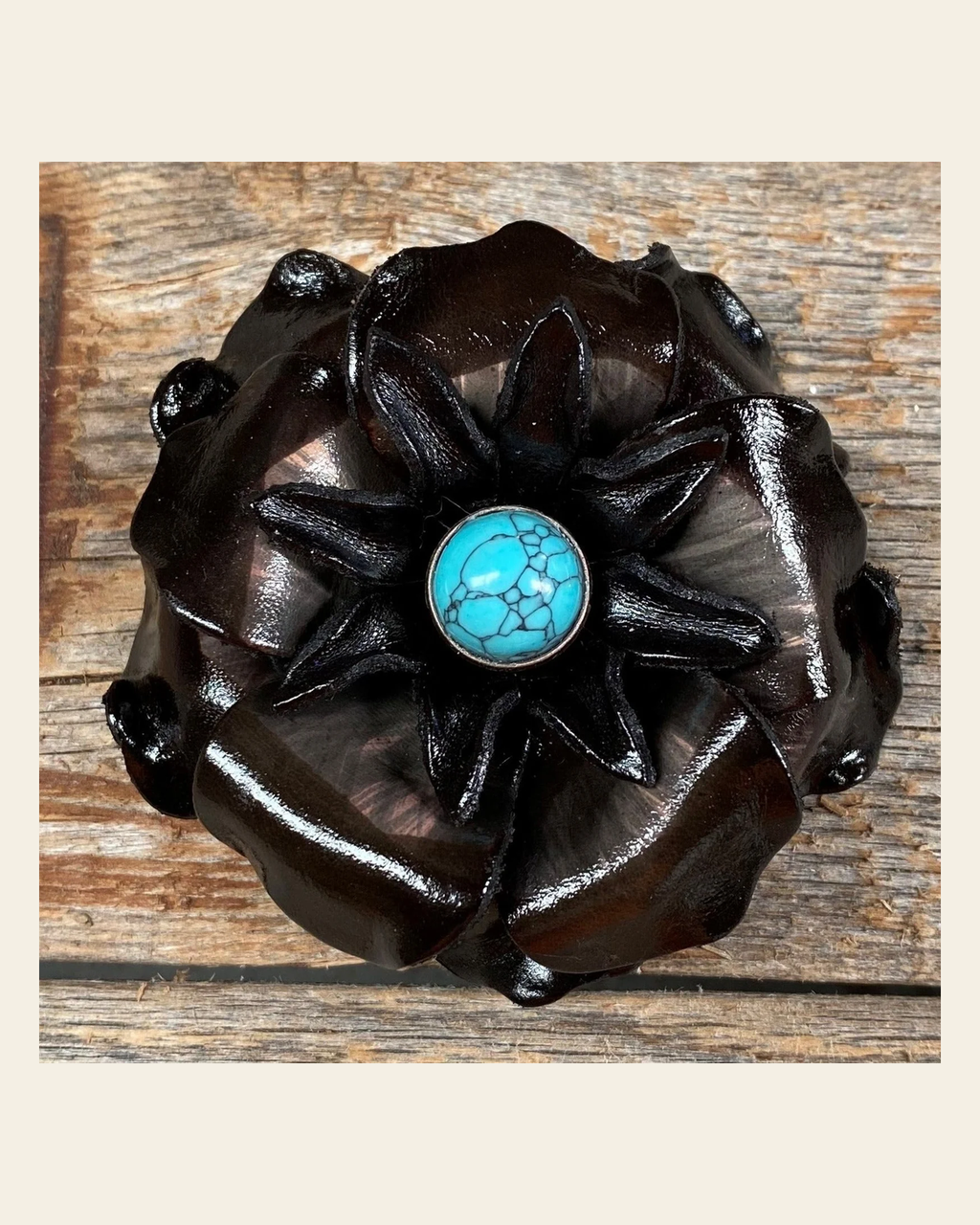 Black Gardenia Flower With Round Turquoise Cabochon on a warm cream background