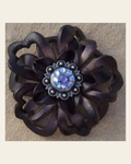 Black Lotus Flower With Antique Silver Lilac and Light Sapphire 1" Concho on a warm cream background