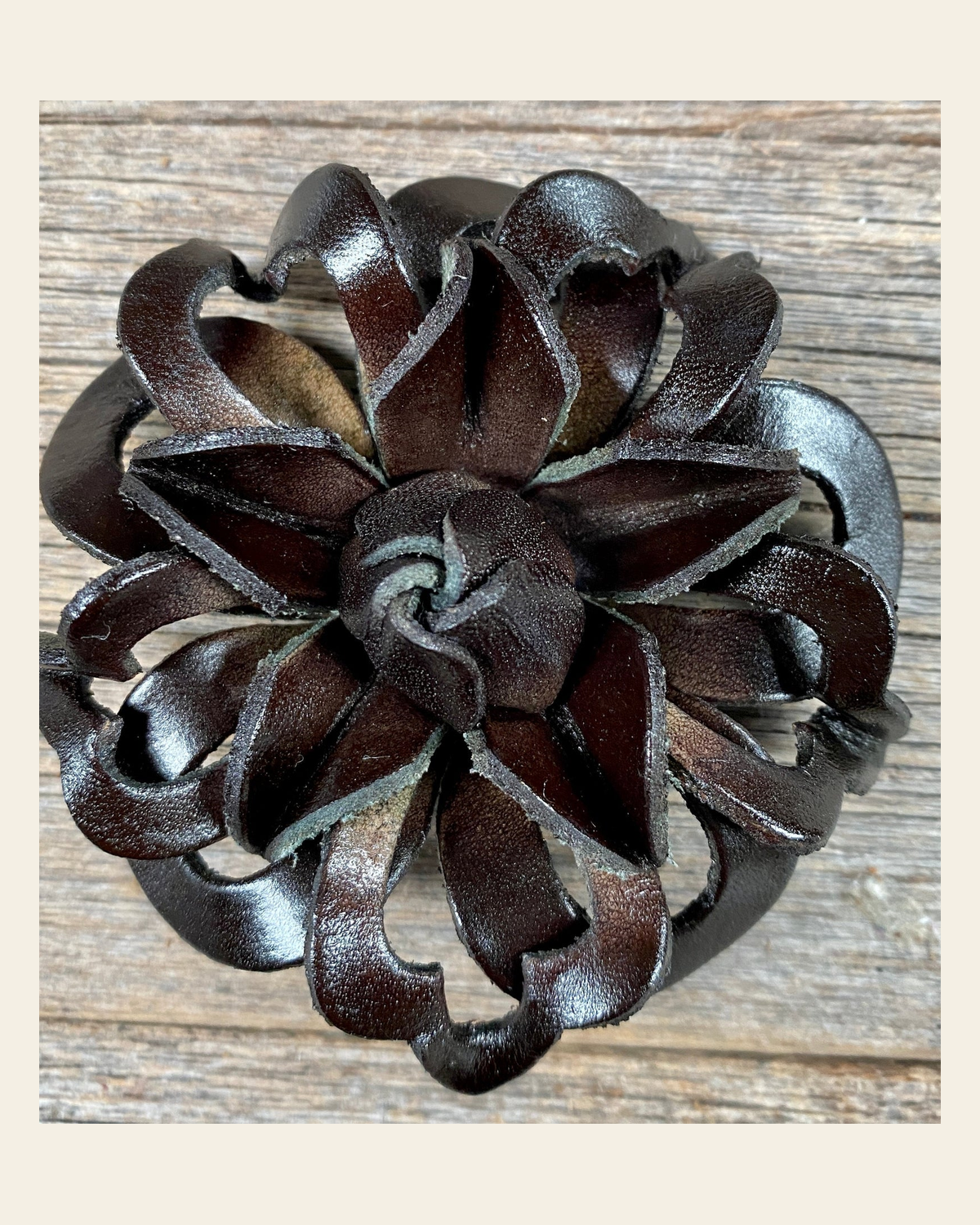Black Lotus Leather Flower on a warm cream background