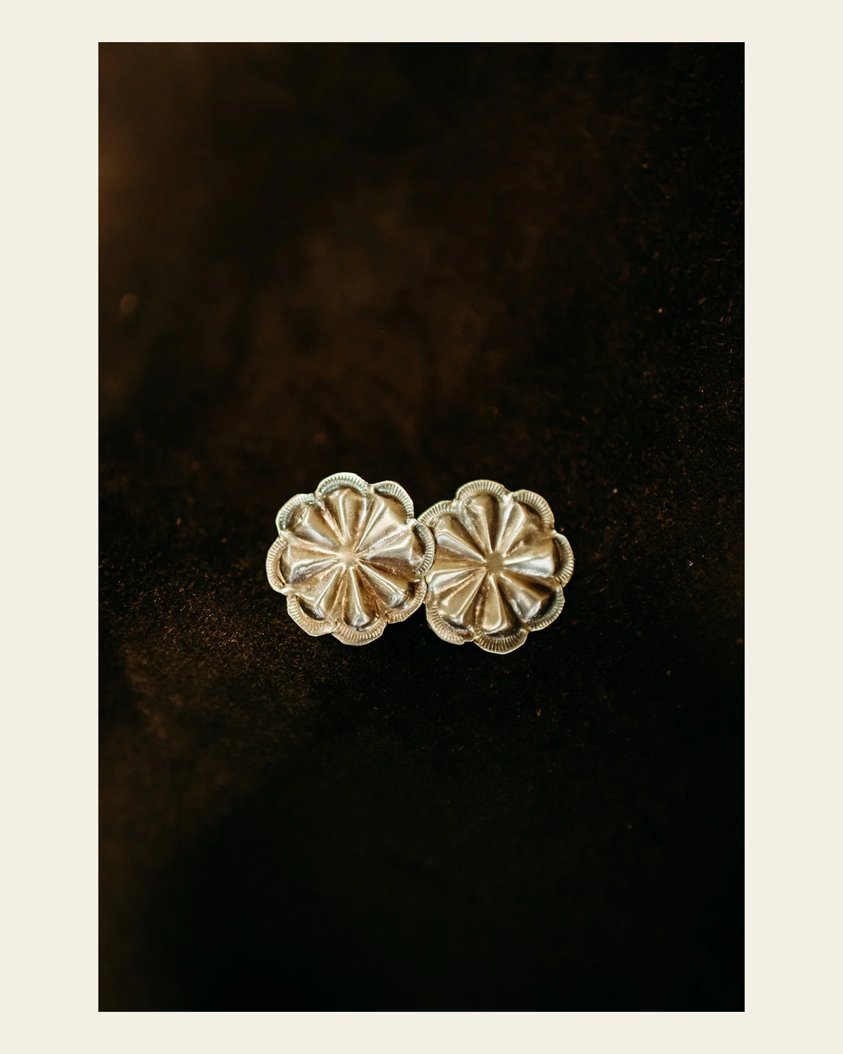 Joan Begay Navajo Made Sterling Silver Concho Earring on a warm cream background