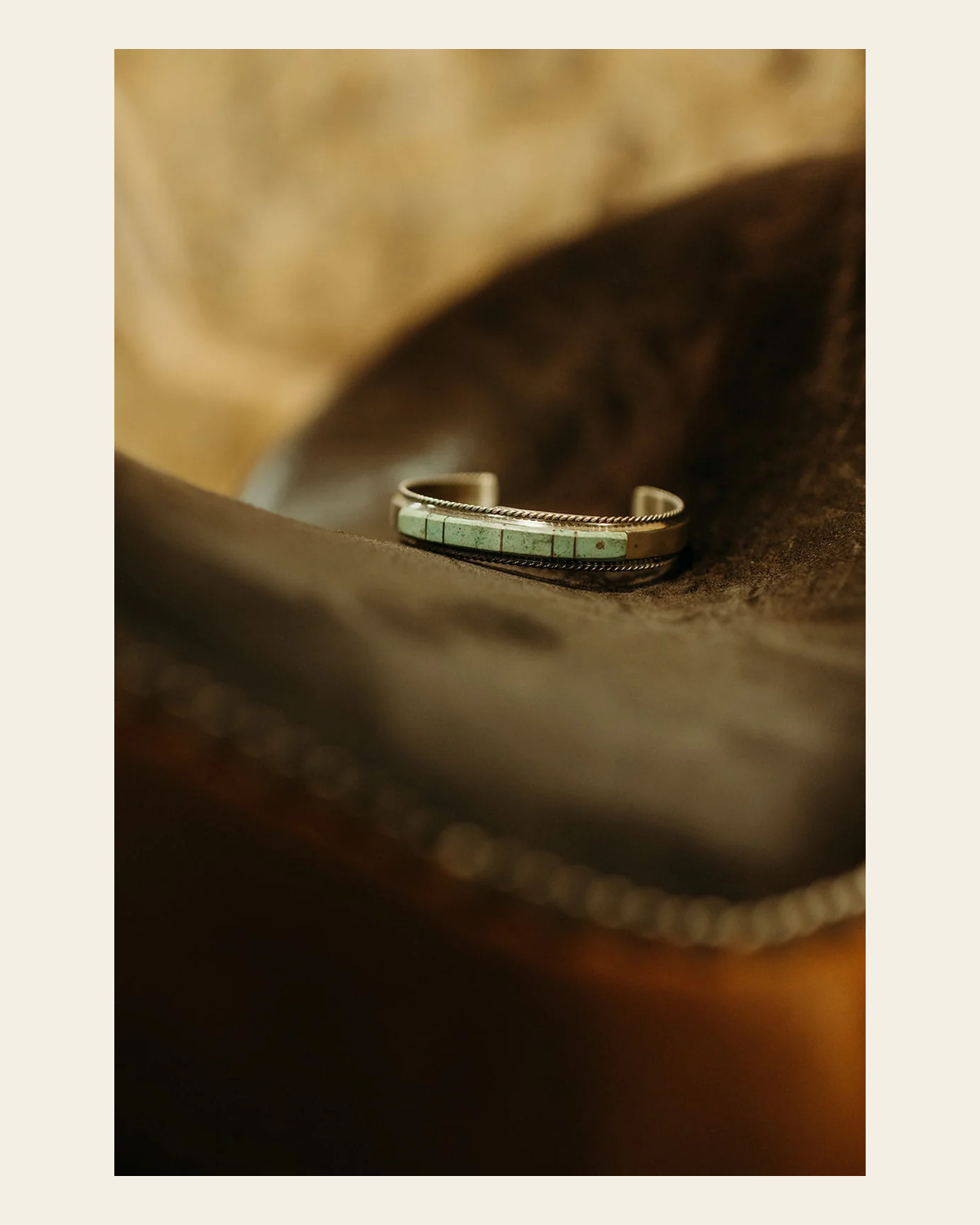Kingman Turquoise Inlay Cuff Bracelet By Francis Yazzie on a warm cream background