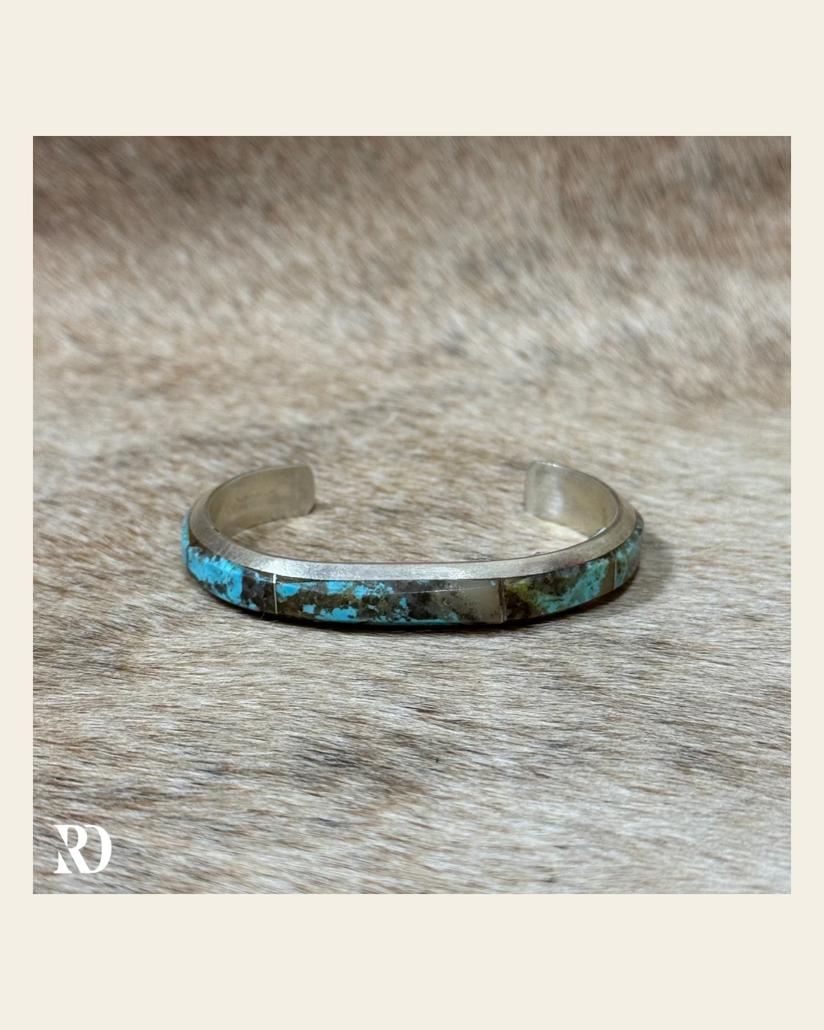 Kingman Turquoise Inlay Cuff By Brandon Etcity on a warm cream background