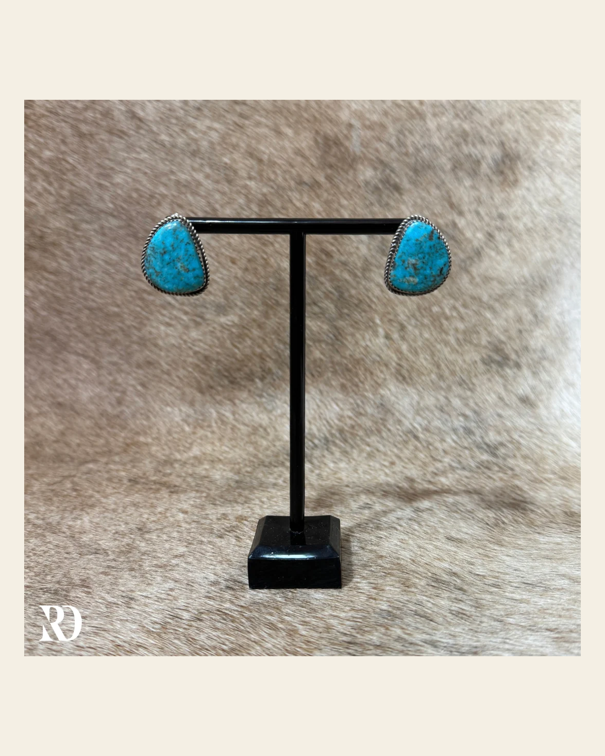 Kingman Turquoise Stud Earrings By Donovan Nez on a warm cream background