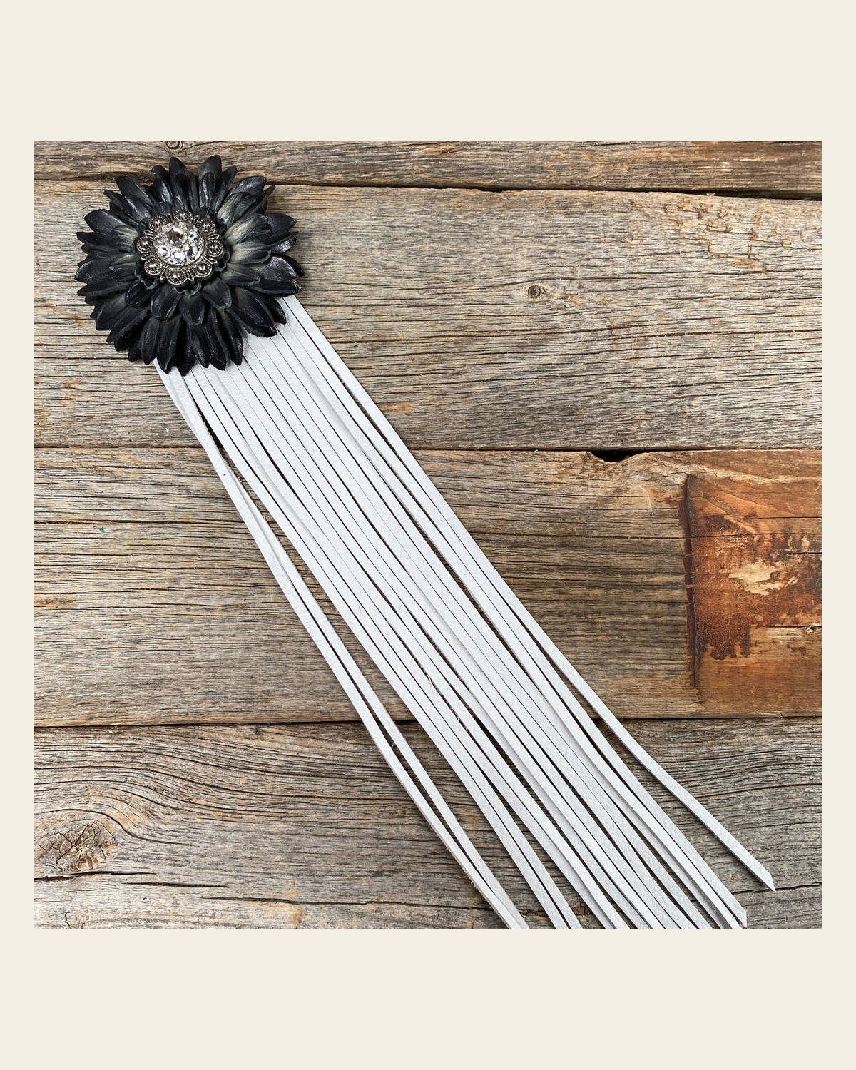 Leather Black Daisy with White Fringe on a warm cream background