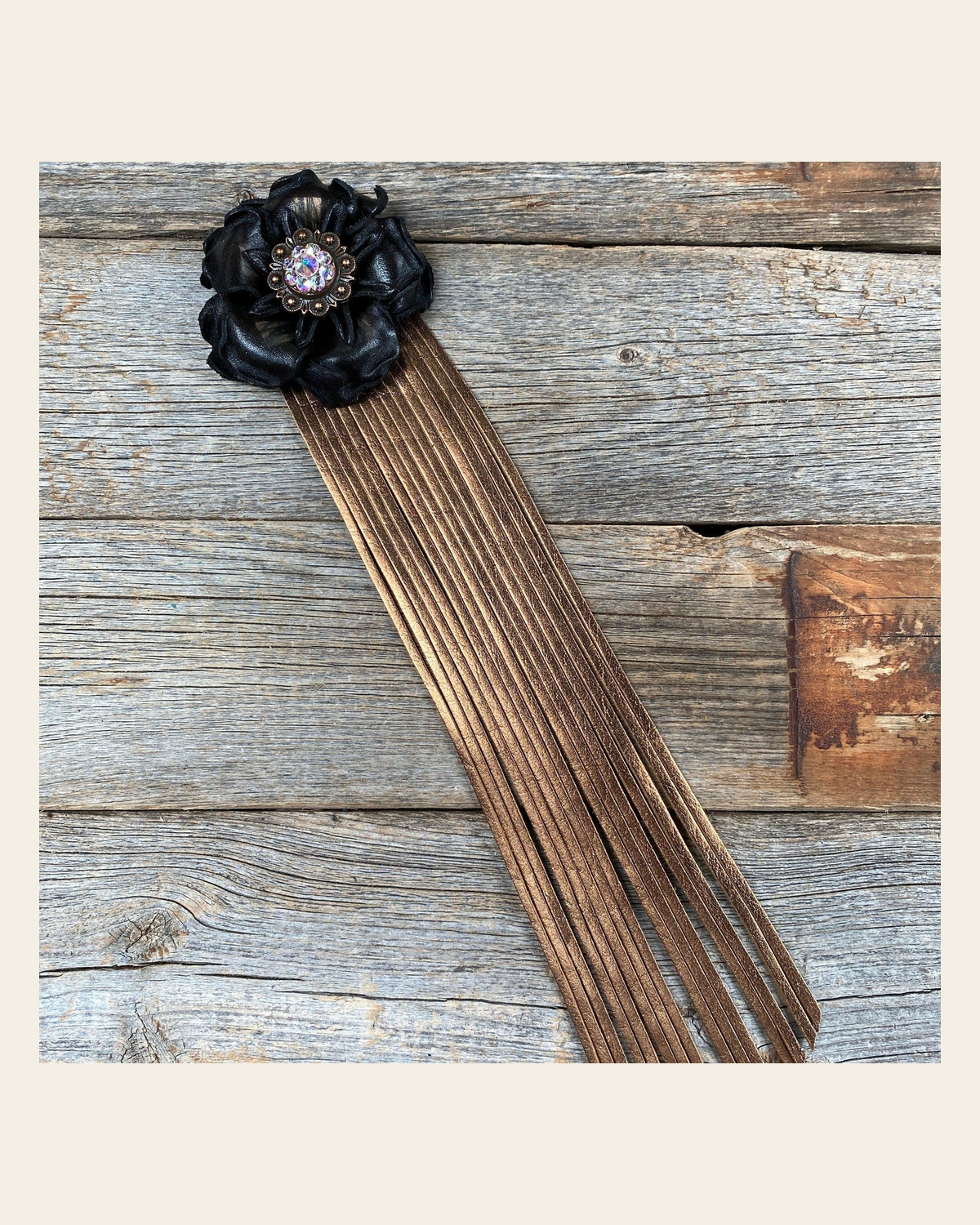 Leather Black Gardenia with Copper Fringe on a warm cream background