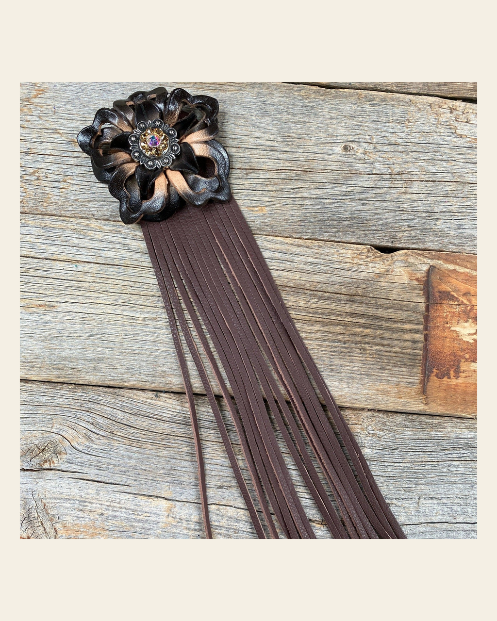 Leather Black Lotus with Brown Fringe on a warm cream background