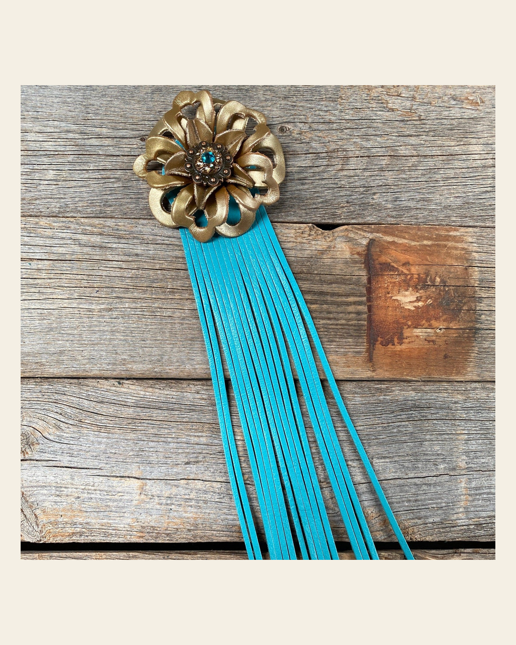 Leather Gold Lotus with Turquoise Fringe on a warm cream background