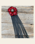 Leather Red Gardenia with Black Fringe on a warm cream background