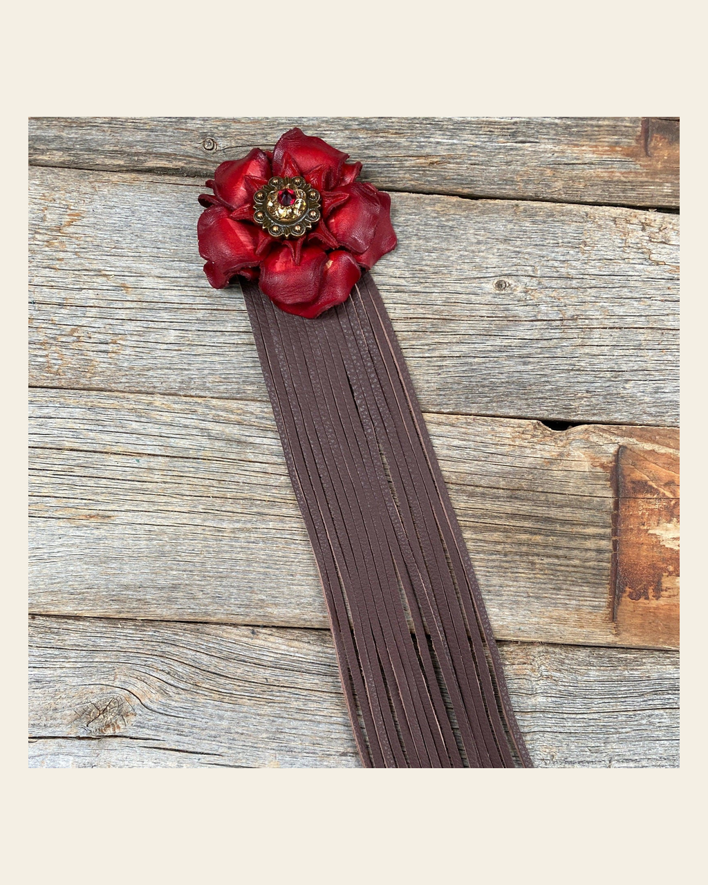 Leather Red Gardenia with Brown Fringe on a warm cream background