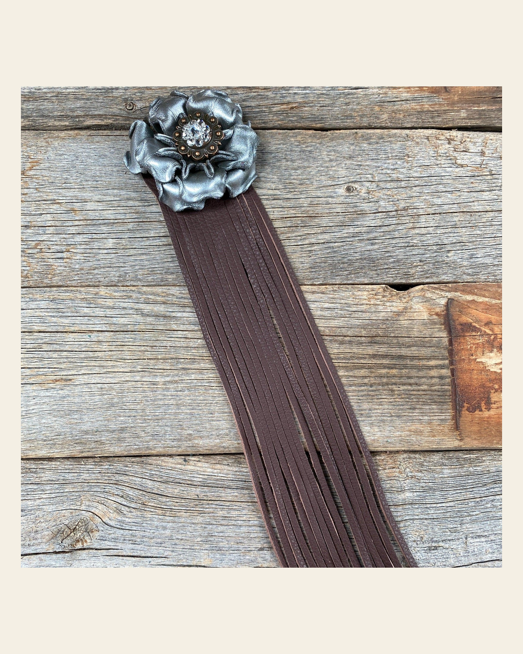 Leather Silver Gardenia with Brown Fringe on a warm cream background