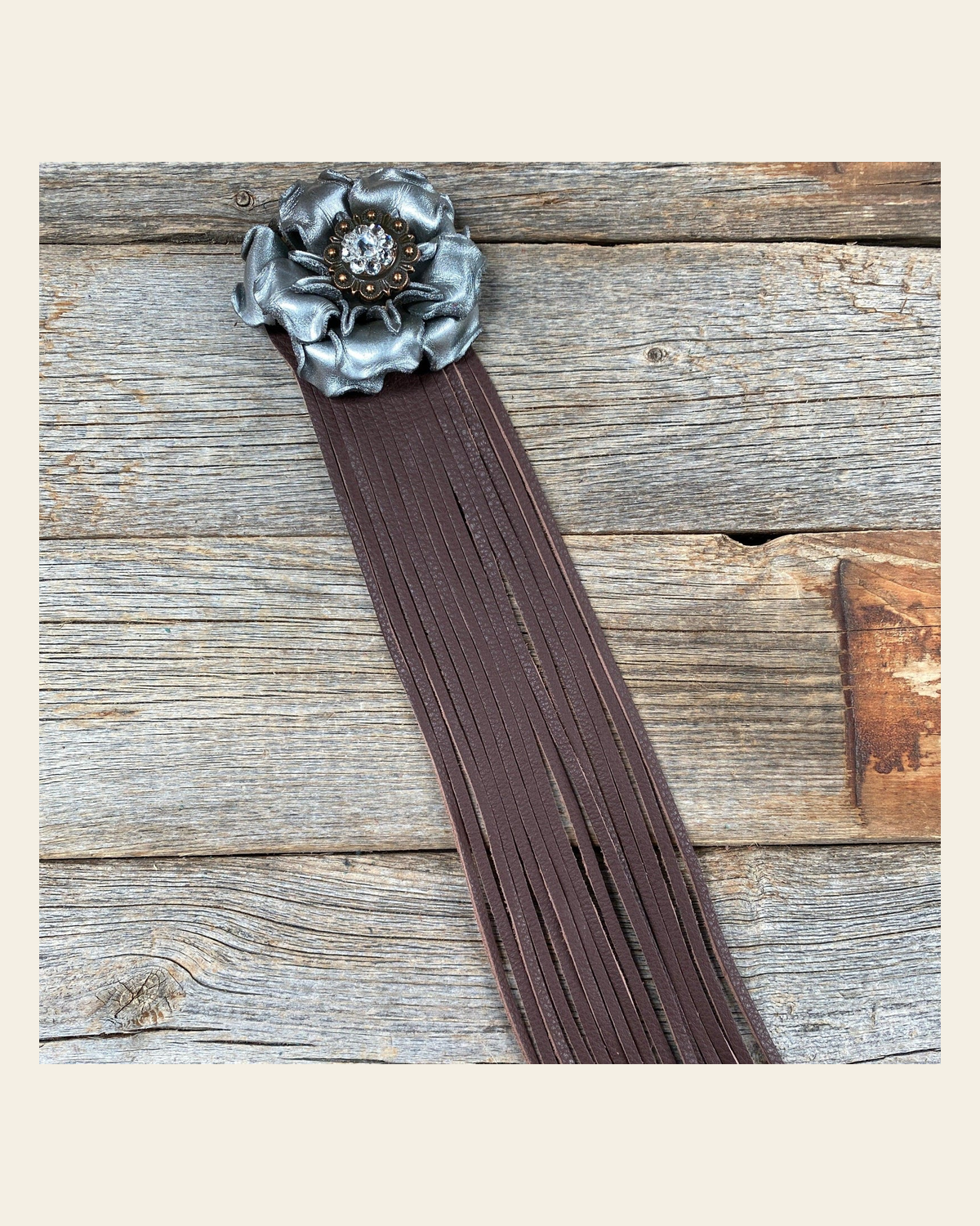 Leather Silver Gardenia with Brown Fringe on a warm cream background