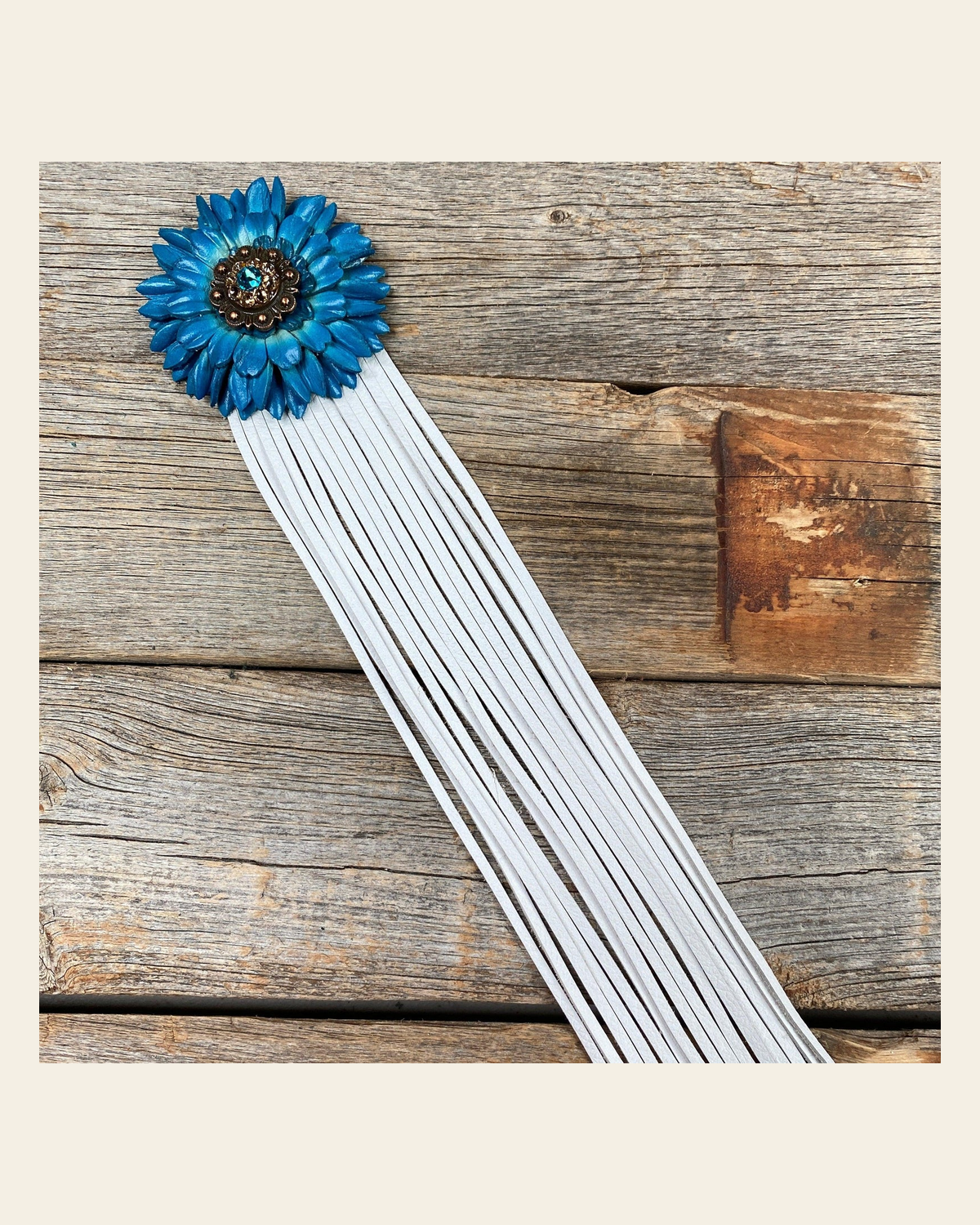 Leather Turquoise Daisy with White Fringe on a warm cream background