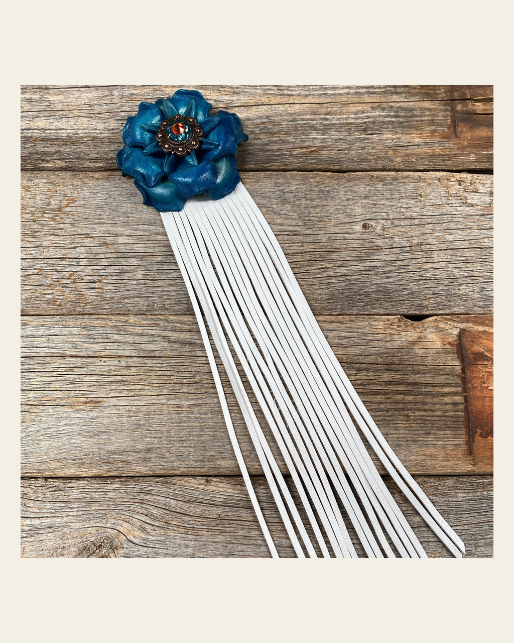 Leather Turquoise Gardenia with White Fringe on a warm cream background