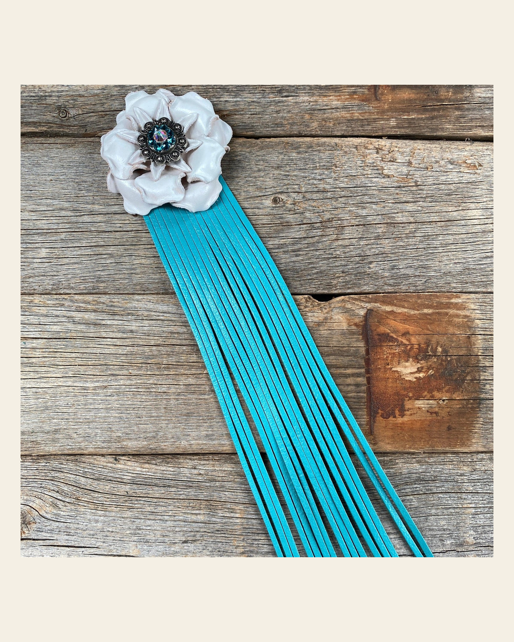 Leather White Gardenia with Turquoise Fringe on a warm cream background
