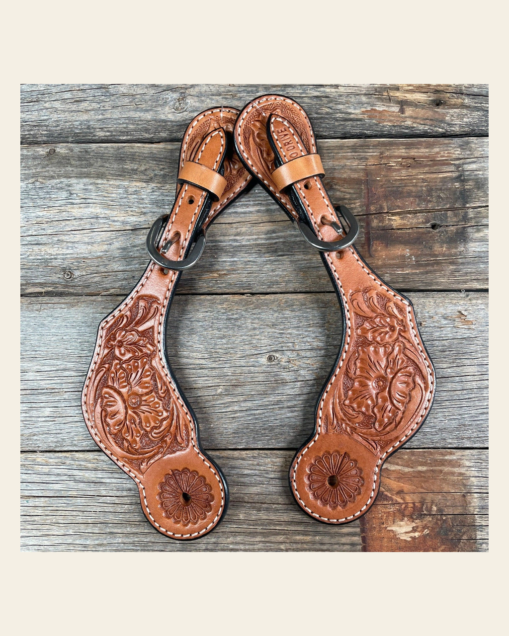 Light Oil Genuine Leather Floral Tooled Spur Straps on a warm cream background