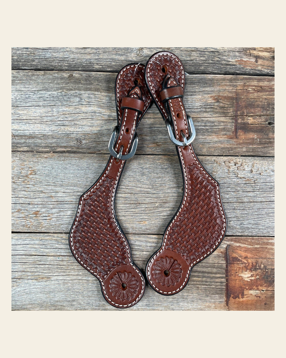 Medium Oil Genuine Leather Basketweave Tooled Spur Straps on a warm cream background