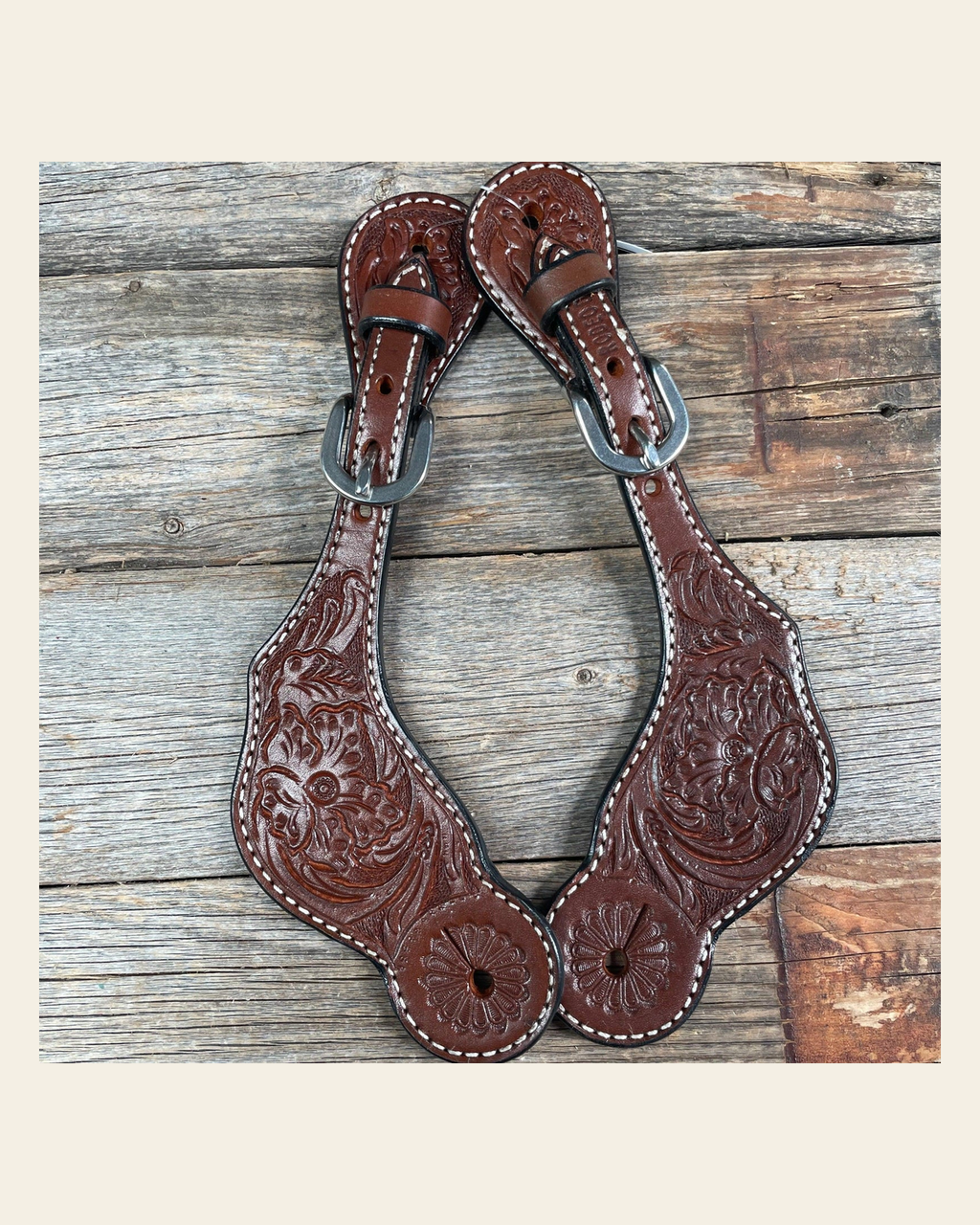 Medium Oil Genuine Leather Floral Tooled Spur Straps on a warm cream background