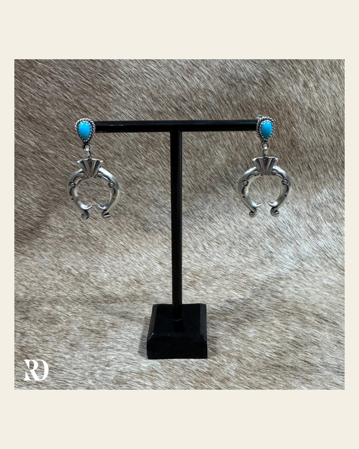 Naja Dangle Kingman Turquoise Earrings By Annette Chiqito on a warm cream background