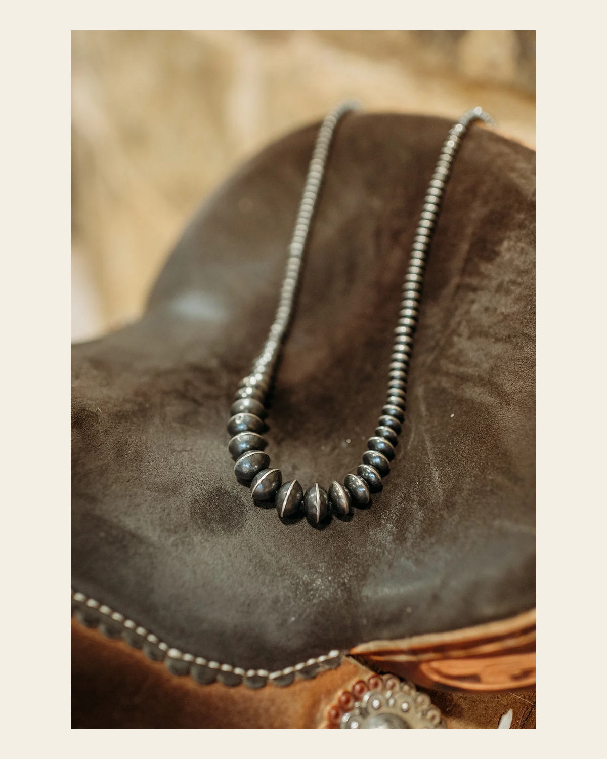 Navajo Inspired 26" Graduated Saucer Pearl Sterling Silver Necklace on a warm cream background