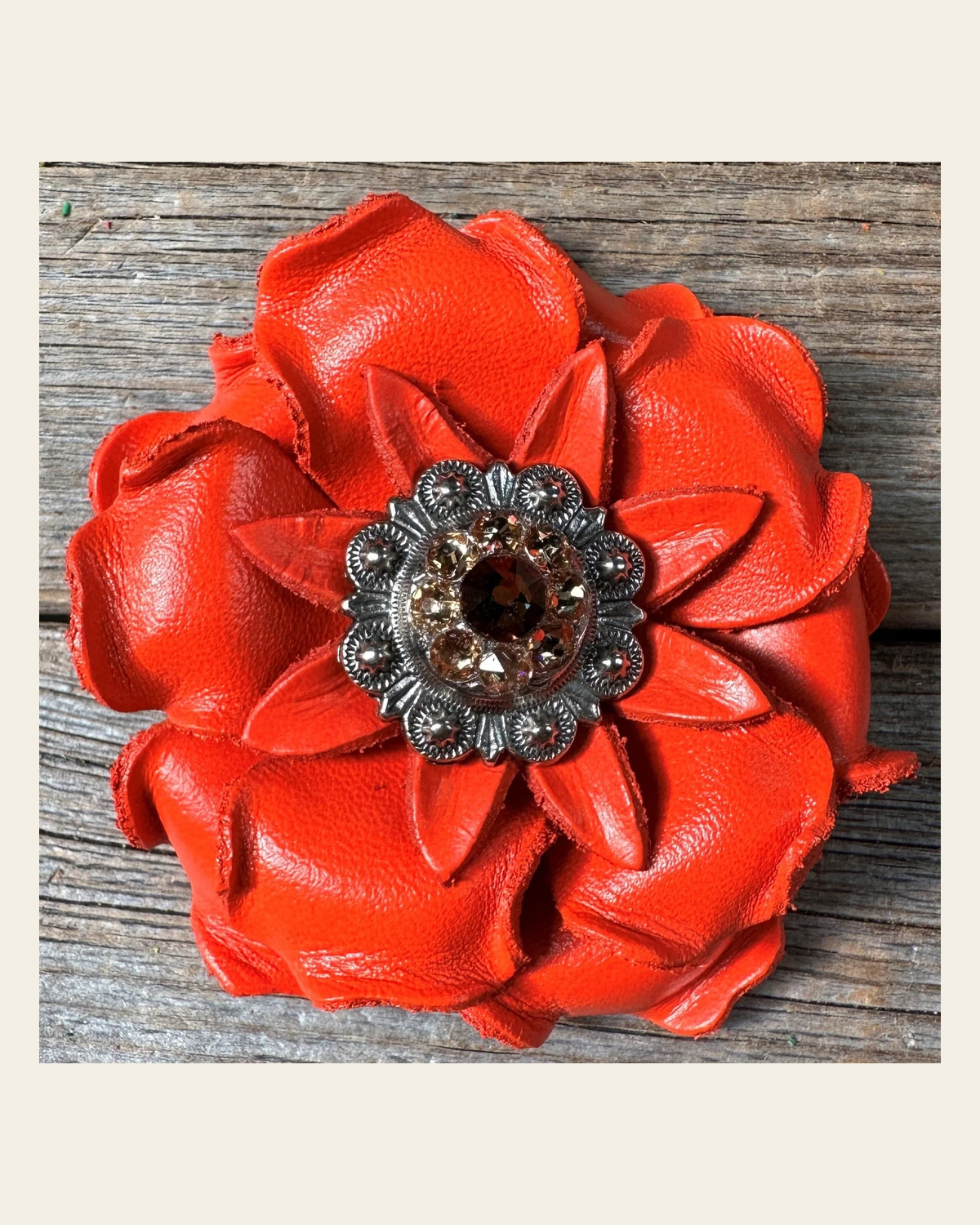 Neon Orange Gardenia Flower With Antique Silver Topaz & Champagne 1" Concho on a warm cream background