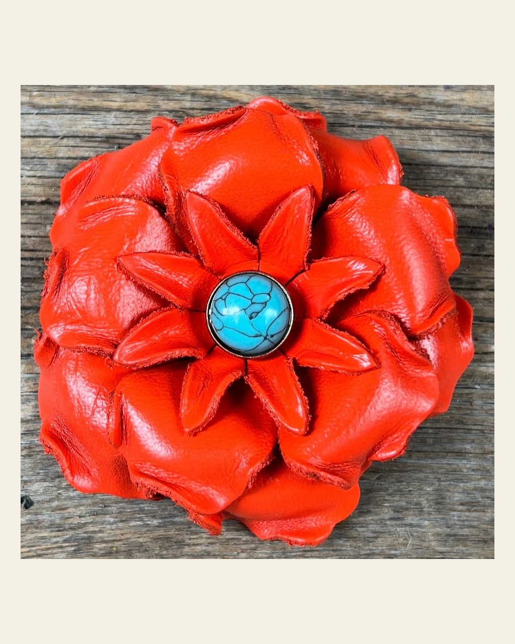 Neon Orange Gardenia Flower With Round Turquoise Cabochon on a warm cream background