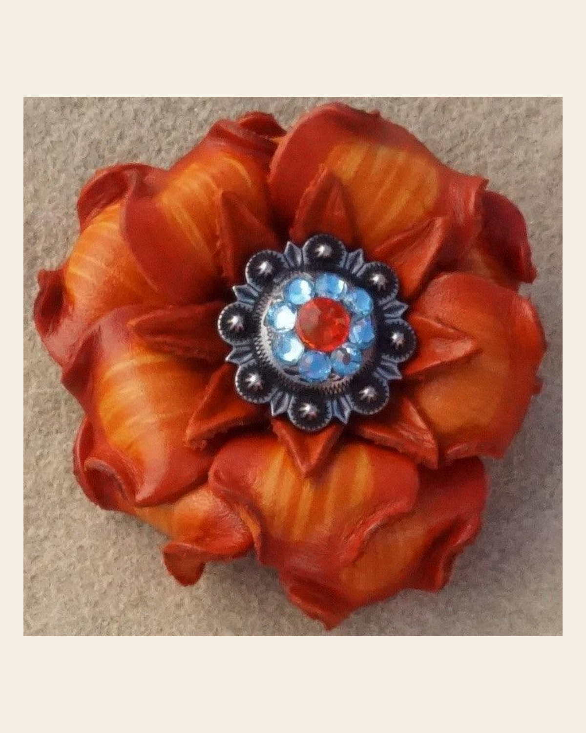 Orange Gardenia Flower With Antique Silver Fire Opal and Aqua 1" Concho on a warm cream background