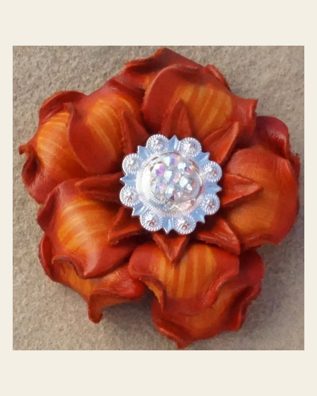 Orange Gardenia Flower With Bright Silver AB 1" Concho on a warm cream background